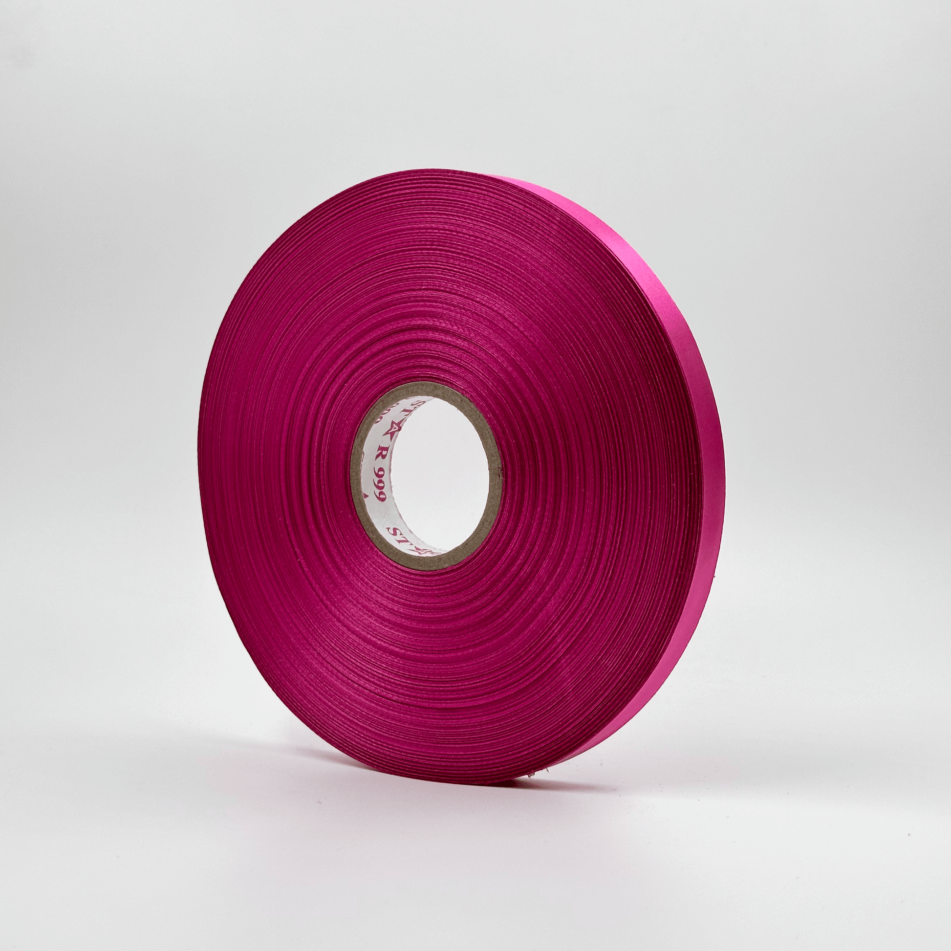 A roll of magenta satin ribbon