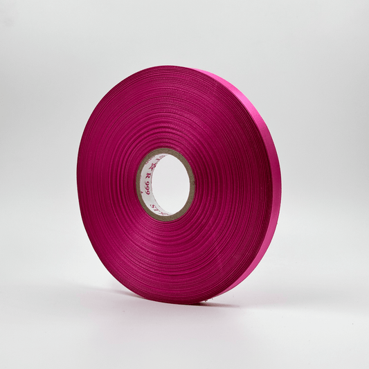 A roll of magenta satin ribbon 